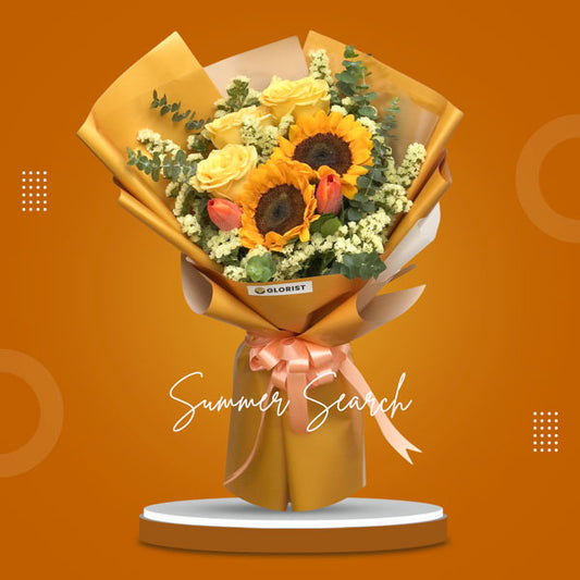 An exquisite bouquet showcasing the vibrant beauty of Sunflowers, Ecuadorian Roses, and Tulips, accentuated with Statice and Eucalyptus Fillers. The bouquet is expertly arranged in a Korean Wrap, adding a touch of uniqueness, and adorned with a luxurious Satin Ribbon, creating a stunning visual appeal.