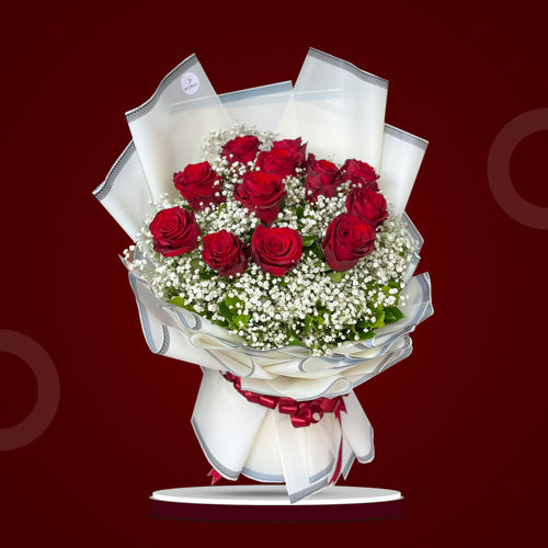 Dreamland Season Bouquet featuring 12 vibrant Ecuadorian roses complemented by delicate gypsophila accents in an elegant arrangement.