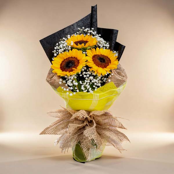 Sunny trio: Bouquet featuring 3 sunflowers and delicate Gypsophila fillers, wrapped in tissue paper, burlap, and net for a rustic touch of charm. Perfect for delivery to SM Megamall and SM City North EDSA.