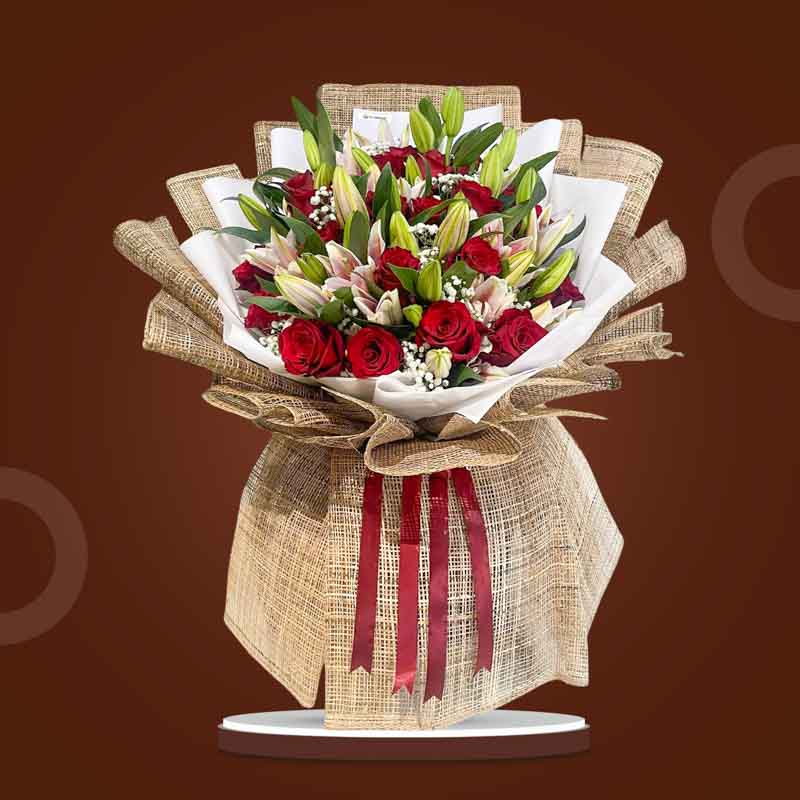 Artistic Love bouquet with red Ecuadorian roses, stargazer lilies, and baby’s breath wrapped in burlap and white Korean paper with maroon ribbon