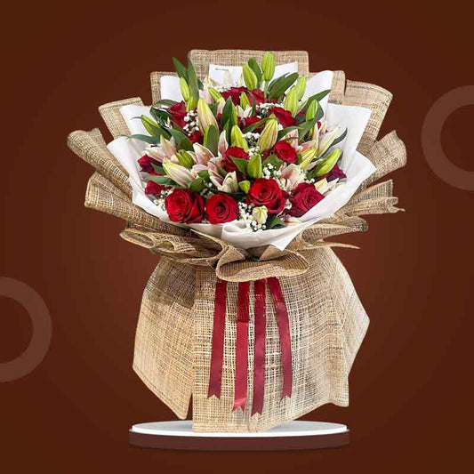 Artistic Love bouquet with red Ecuadorian roses, stargazer lilies, and baby’s breath wrapped in burlap and white Korean paper with maroon ribbon