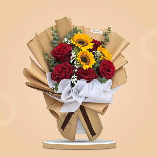 Blush Love bouquet with red Ecuadorian roses, sunflowers, eucalyptus, and baby’s breath in kraft Korean wrap and brown ribbon