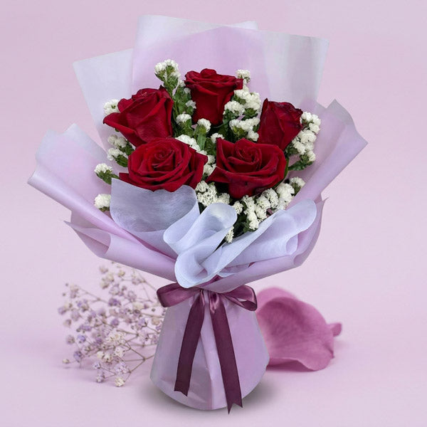 Calm Dreamland bouquet with 5 red Ecuadorian roses and white statice in light violet and white wrap tied with an old rose ribbon