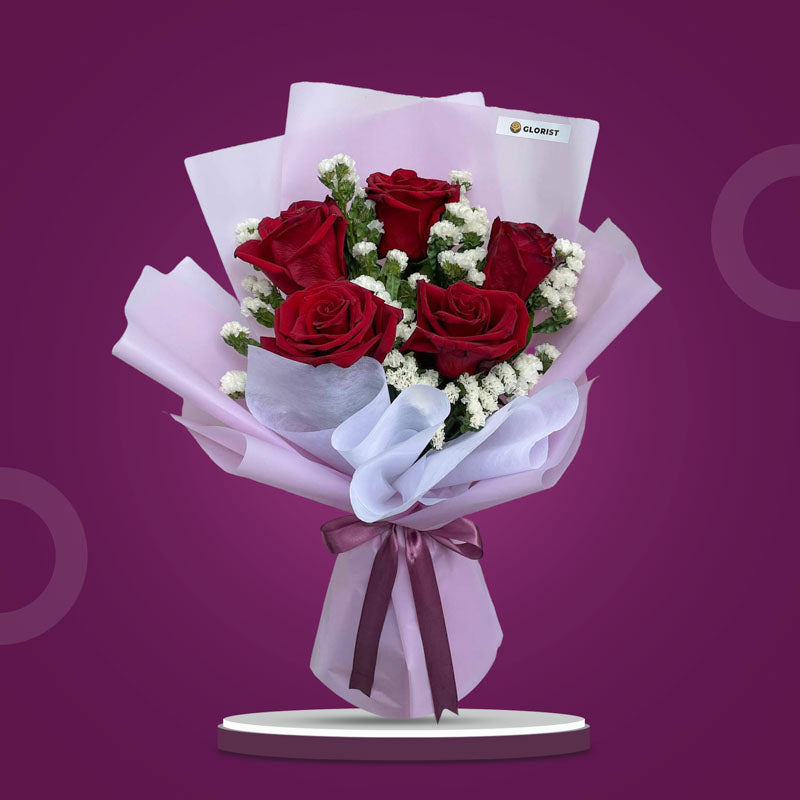 Calm Dreamland bouquet with 5 red Ecuadorian roses and white statice in light violet and white wrap tied with an old rose ribbon