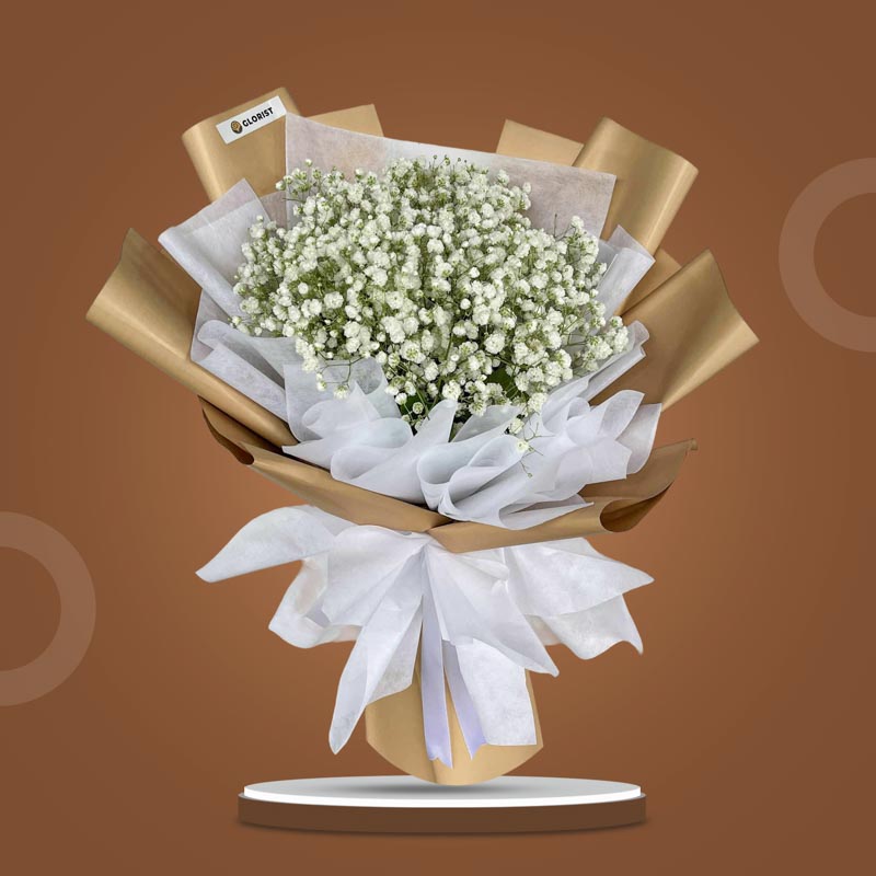 Coral Snow bouquet with white Gypsophila Baby’s Breath in kraft and white wrap with white ribbon