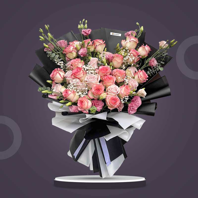Diamond Love bouquet with 30 light pink roses, lisianthus, eucalyptus, and baby’s breath in black and white Korean wrap with white ribbon