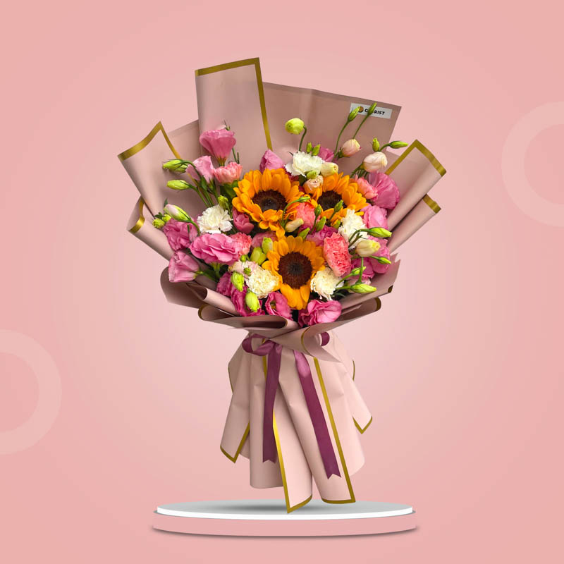Gold Love bouquet with sunflowers, lisianthus, white and pink carnations in dirty pink wrap and old rose ribbon