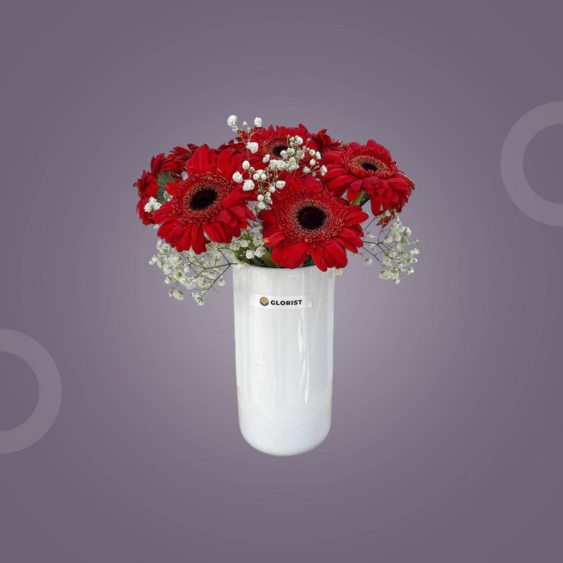 Inspired Fresh Flower Vase with ten red gerbera daisies and white baby’s breath in a clear glass vase