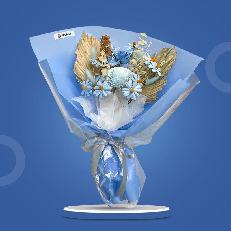 Lapis Timeless dried bouquet with light blue sola chrysanthemum, sola daisies, lotus wooden blue, bleached eucalyptus, bunny tails and anahaw leaves in light blue and white wrap with transparent cover