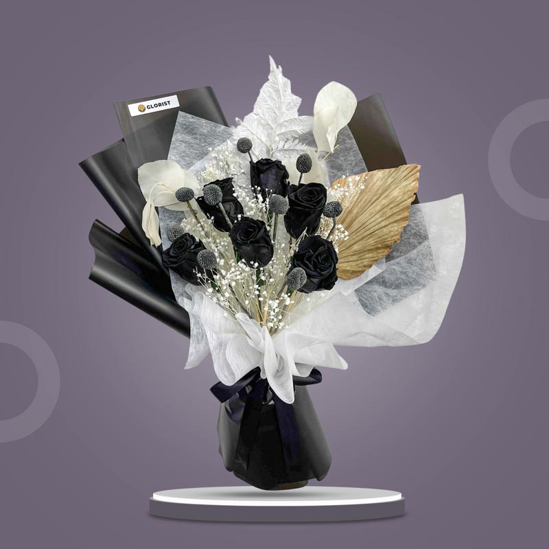 Obsidian Timeless dried bouquet with preserved black roses, black craspedia, bleached silver dollar eucalyptus, bleached gypsophila, and anahaw leaf in black wrap with black ribbon