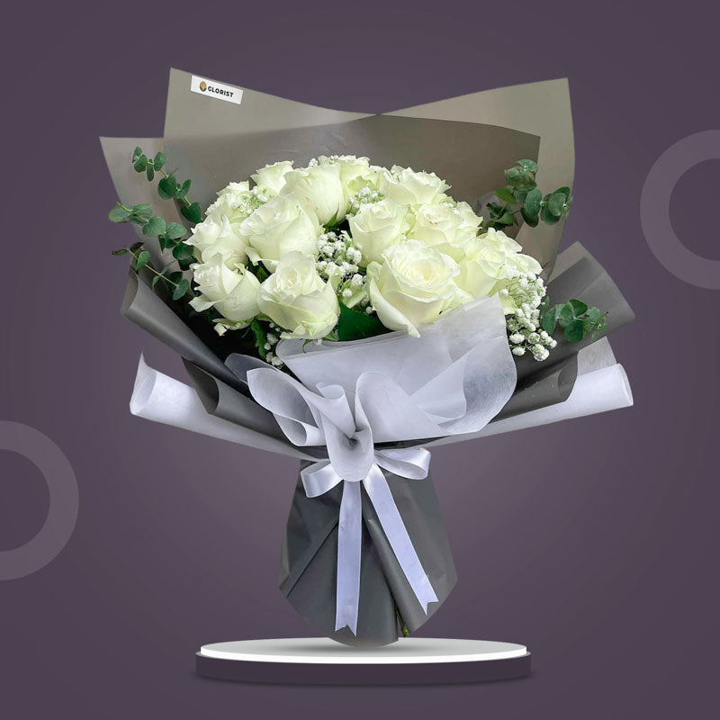 Resilient Flora bouquet with 20 white China roses, eucalyptus baby blue, and gypsophila baby’s breath in dark gray and white wrap tied with a white ribbon