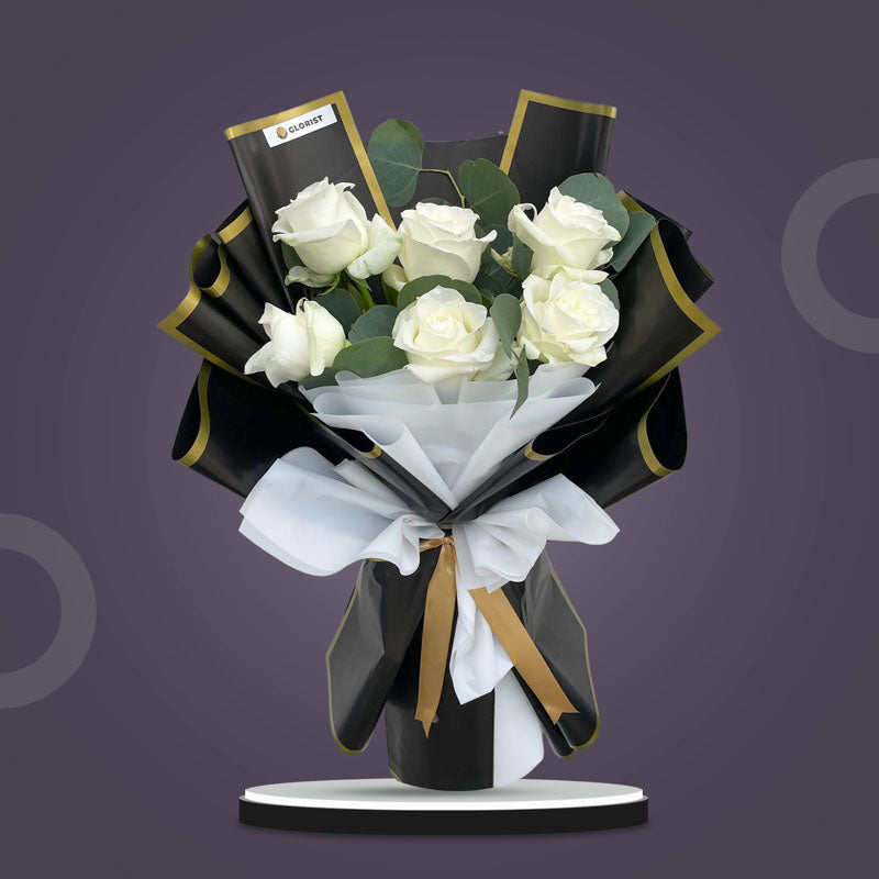 Savvy Flora bouquet with 6 white China roses and eucalyptus silver dollar in black‑bordered and white Korean wrap with light gold ribbon