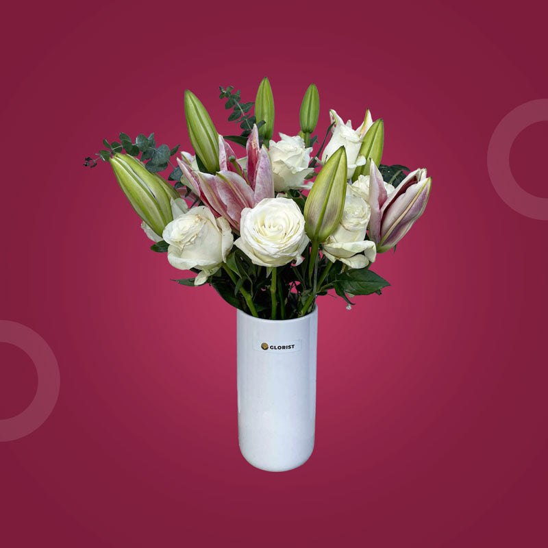 Sparkly Fresh Flower Vase with three stargazer lilies, ten white China roses, and eucalyptus baby blue in a clear glass vase