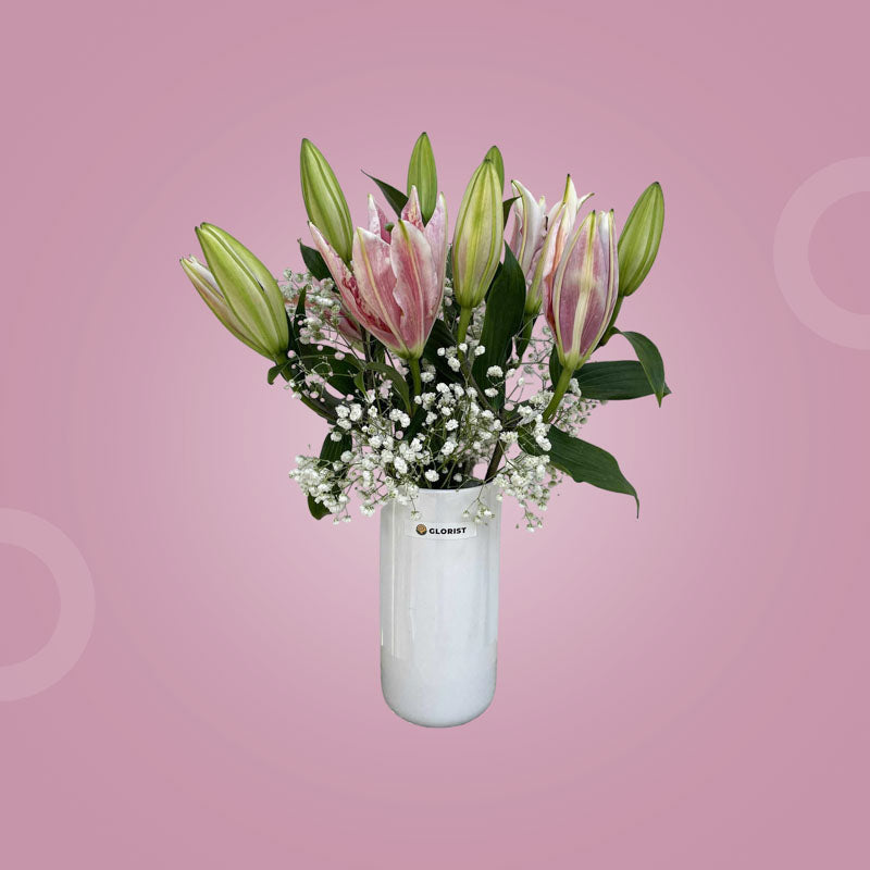 Stellar Fresh Flower Vase with three pink stargazer lilies and one baby’s breath stem in a clear glass vase