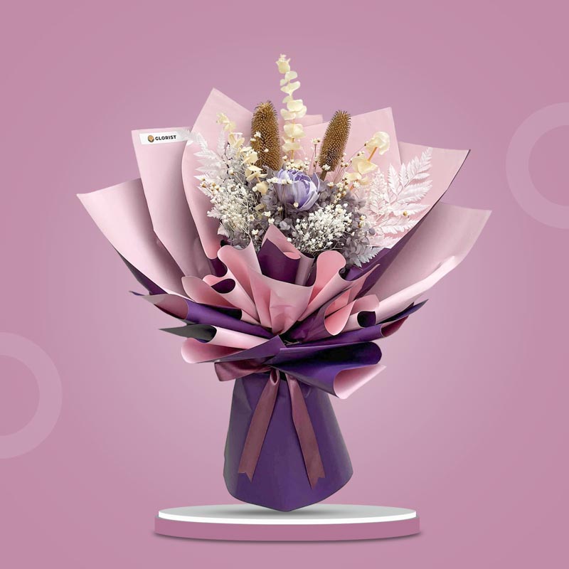 Sugilite Timeless dried bouquet with purple sola peony, dusty purple hydrangea, bleached gypsophila, eucalyptus, tiny star flowers, and white ferns in purple wrap with old rose ribbon
