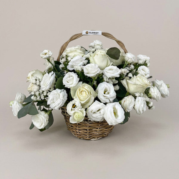 White China roses with lisianthus, white statice, and eucalyptus silver dollar in a handwoven basket, an elegant wedding and sympathy gift with same-day Metro Manila delivery