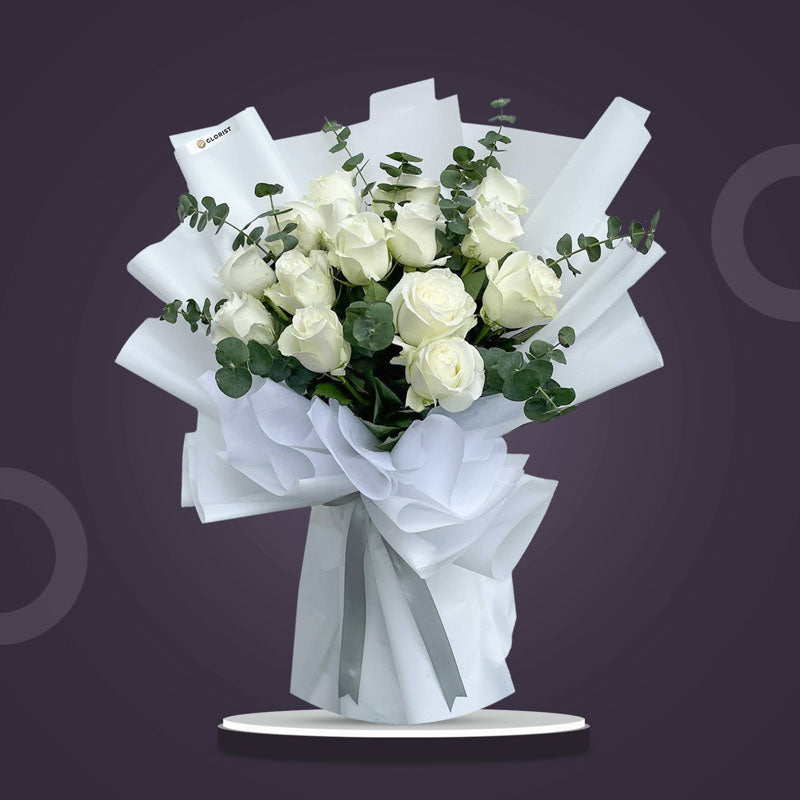 Willing Flora bouquet with 15 white China roses and eucalyptus baby blue in white Korean and non‑woven wrap tied with a silver ribbon
