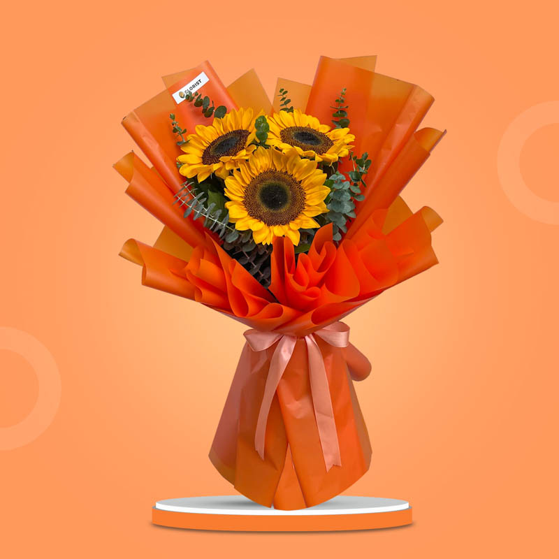 Zestful Summer bouquet with three sunflowers and eucalyptus in orange Korean wrap tied with salmon ribbon