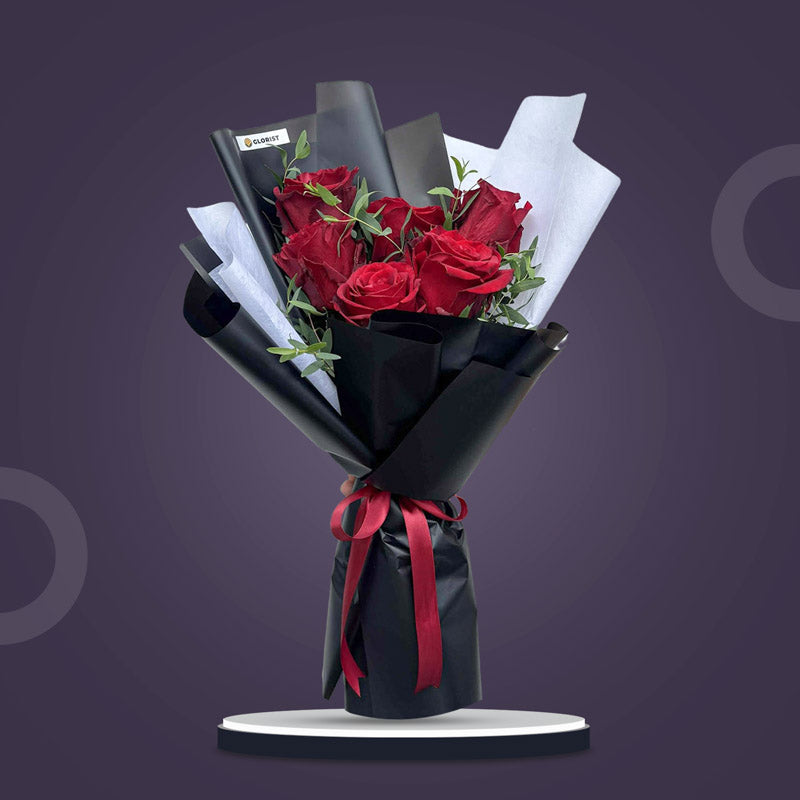 Zircon Dreamland bouquet with 6 red Ecuadorian roses and eucalyptus parvi in black and white wrap, tied with a maroon ribbon
