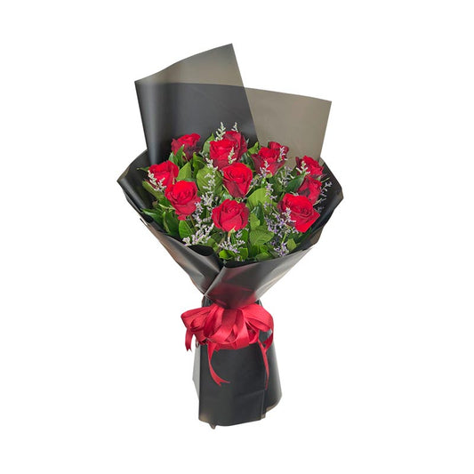 Elegant one dozen red roses with misty blue fillers in a Korean wrap, adorned with a satin ribbon for a touch of luxury.