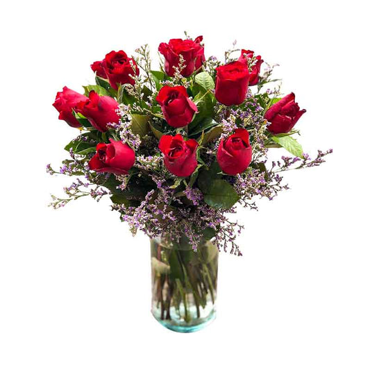 Definite vase arrangement with a stunning combination of 12 red Baguio roses and delicate Misty Blue flowers, artfully arranged in a clear glass vase. A captivating display of freshness and beauty.