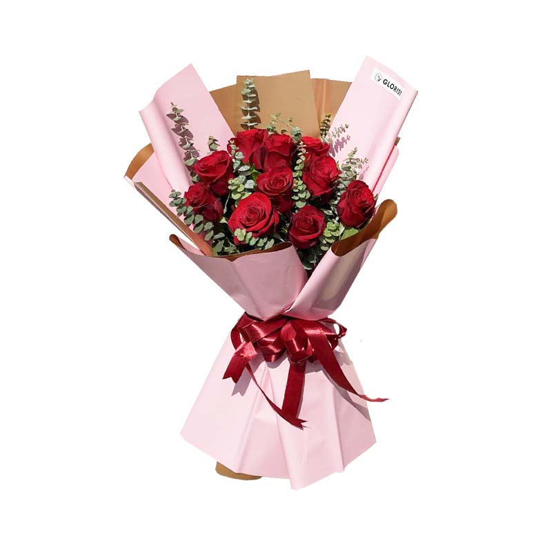 Fantasy Fold: An exquisite arrangement adorned with 10 imported Red China Roses and delicate Eucalyptus, elegantly wrapped in a two-toned light pink gold Korean film, creating a captivating display of beauty and sophistication.