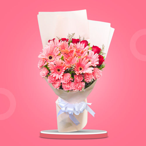 Stunning floral arrangement with light pink gerberas, carnations, red roses, and misty blue fillers in a Korean wrap. Enhanced with a satin ribbon for an elegant touch. Perfect for weddings and special occasions. Flower delivery in Cavite City, Cavite.