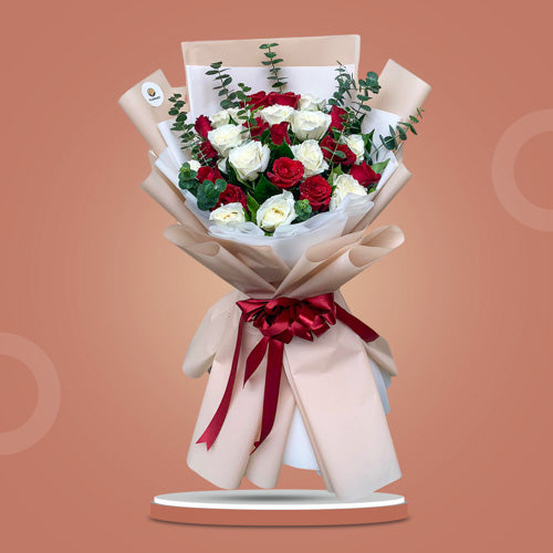 Connect Dreams bouquet featuring 12 red roses, 12 white roses, and eucalyptus, elegantly wrapped with a satin ribbon.