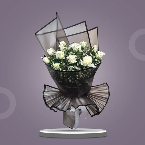 Excellent Dreams bouquet featuring 12 white roses surrounded by aster fillers and lush greenery, elegantly arranged for any occasion.