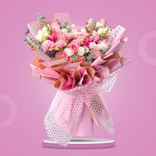 Oasis Love bouquet featuring light pink China roses, pink carnations, white roses, snapdragons, and eucalyptus, elegantly wrapped in Korean and net wrap.