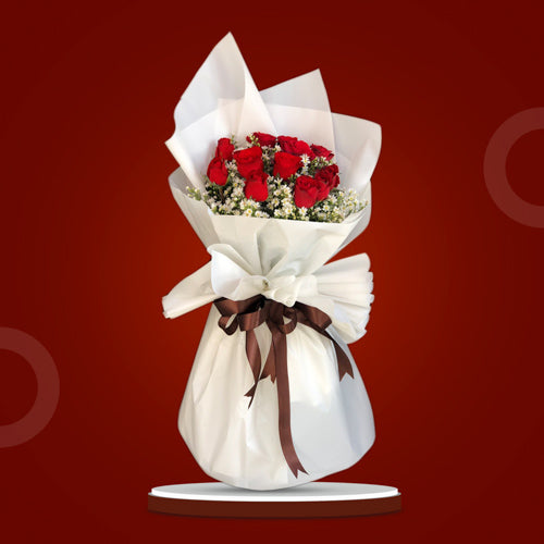 Ruby Dreams bouquet featuring 12 red roses with aster fillers, elegantly wrapped in Korean-style film and adorned with a satin ribbon.