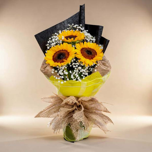 Sunny trio: Bouquet featuring 3 sunflowers and delicate Gypsophila fillers, wrapped in tissue paper, burlap, and net for a rustic touch of charm. Perfect for delivery to SM Megamall and SM City North EDSA.
