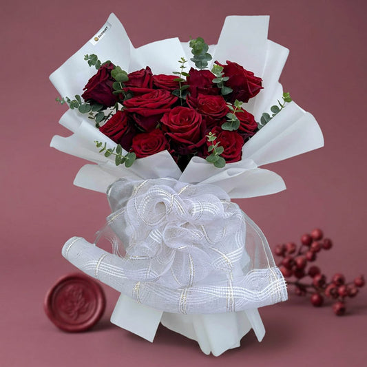 Angelic Dreamland bouquet with 12 red Ecuadorian roses and eucalyptus baby blue wrapped in white paper with mesh net accents