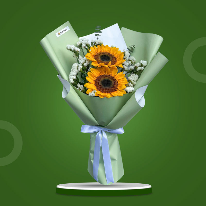 Attractive Summer bouquet with two sunflowers, eucalyptus baby blue, and statice in matcha green wrap with white ribbon