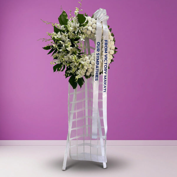 White orchids and stargazer lily funeral flower stand arrangement