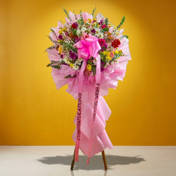 Blooming Launch Inaugural Stand with assorted gerbera daisies and eucalyptus fillers