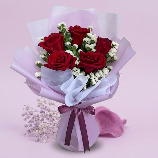 Calm Dreamland bouquet with 5 red Ecuadorian roses and white statice in light violet and white wrap tied with an old rose ribbon
