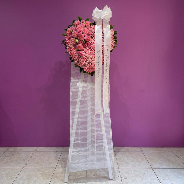 Light pink lisianthus and carnation funeral stand with painted gypsophila