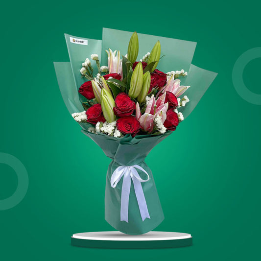 Confident Love bouquet with red roses, stargazer lilies, and statice in emerald green wrap with white ribbon