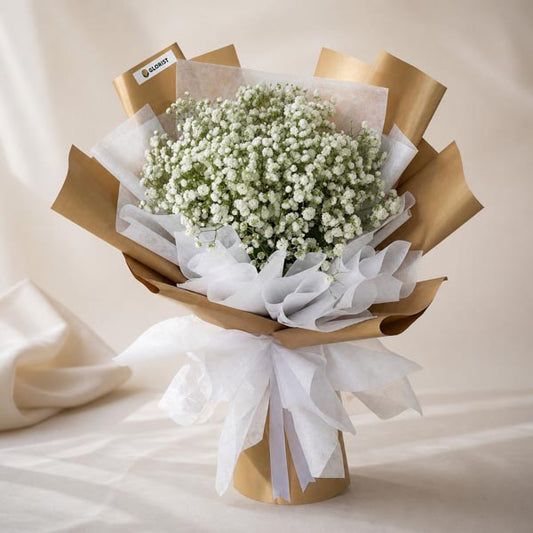 Coral Snow bouquet with white Gypsophila Baby’s Breath in kraft and white wrap with white ribbon