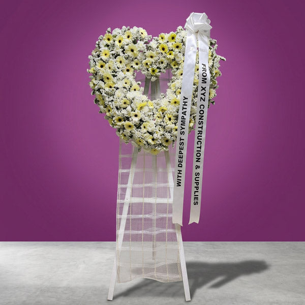 White gerbera and carnation funeral stand with white statice flowers