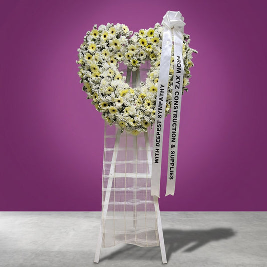 White gerbera and carnation funeral stand with white statice flowers