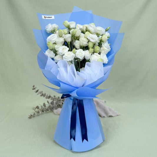 Crimson Fields bouquet with white lisianthus paper roses wrapped in light blue Korean paper and white non-woven, tied with a navy blue ribbon
