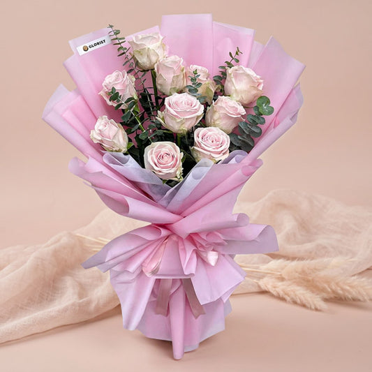 Faithful Flora bouquet with 10 light pink China roses and eucalyptus baby blue in light pink and white wrap tied with a light pink ribbon