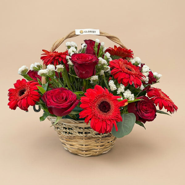 Handwoven flower basket with red gerbera daisies, red China roses, and white statice, ideal for anniversaries and Valentine's Day, same-day Metro Manila delivery