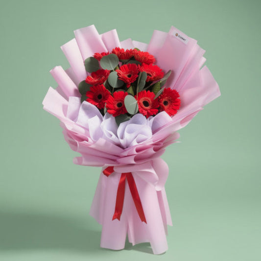 Genuine Adoration bouquet with 10 red Gerbera daisies and Eucalyptus Silver Dollar in light violet wrap with red ribbon