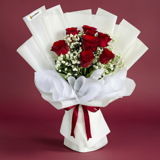 Glossy Flora Flower Bouquet with seven red China roses and baby’s breath wrapped in white Korean and non-woven wrap, tied with a maroon ribbon