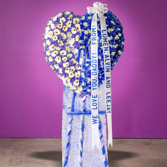 Honorable Memory Funeral Stand with blue carnations, white gerberas, and violet and white statice