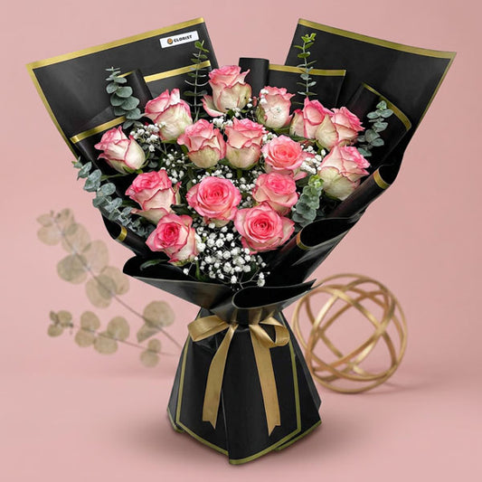 Hope Flora bouquet with 2‑toned light pink China roses, gypsophila baby’s breath, and eucalyptus baby blue in black‑bordered wrap tied with a light gold ribbon