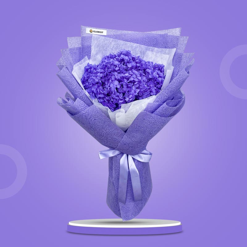 Kunzite Timeless dried bouquet with purple hydrangea in purple tissue and white non-woven wrap with light purple ribbon